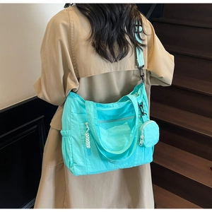Détail du cabas en nylon vert menthe avec poche zippée et petite pochette ronde
