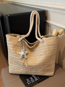 Beige woven straw tote bag with rope handles and star charm for summer beach vacations