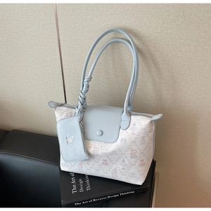 Detail of light blue tote bag with cute rabbit print and matching small pouch charm