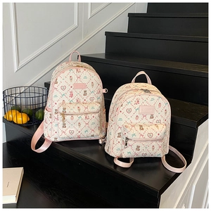 Close-up of stylish backpacks in two sizes with bear print and pink trim details