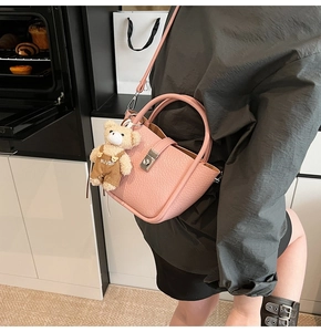 Pink lychee grain leather bucket bag with metal lock and cute teddy bear charm detail