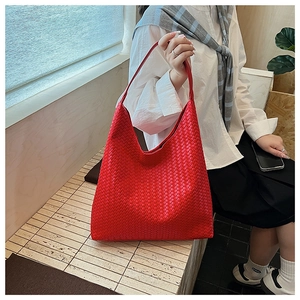 Detail of red woven leather tote bag showing fine texture and large capacity design