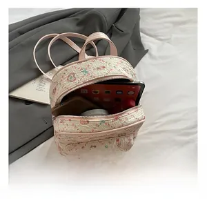 Detail view of the interior capacity showing a tablet and phone inside the floral bear backpack