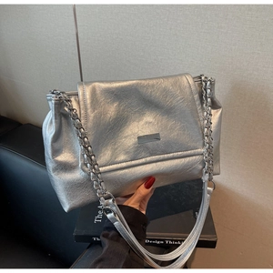 Detail of silver chain shoulder bag featuring metallic crinkle texture and metal buckle