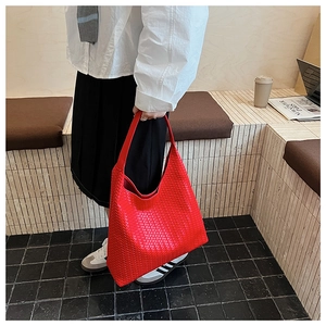 Detail of red woven leather hobo bag showing the intricate square texture and handle