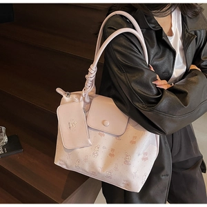 Detail of light pink tote bag with bear patterns and unique knotted strap craftsmanship