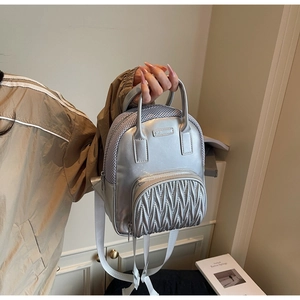 Detailed shot of silver mini backpack featuring wave quilted texture and mesh fabric