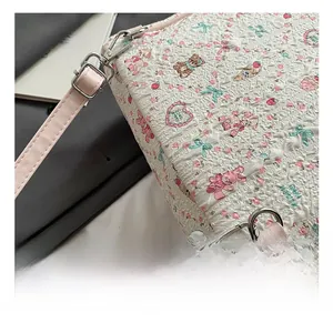 Detail of silver metal hook and pink leather strap on quilted floral backpack