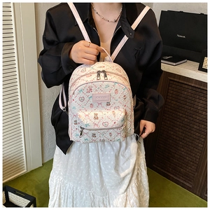 Close-up of white floral bear backpack with metal zippers and textured fabric detail