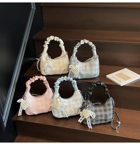 Close-up of quilted chain bags in five colors with pearl bow charms and embroidery