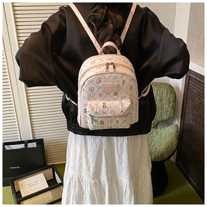 Detailed view of floral beige backpack with vintage bear patterns and premium zippers