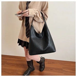 Detailed close-up of premium black woven leather tote bag with large capacity for women