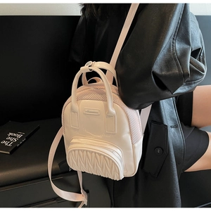 Detail of light pink mini backpack featuring pleated texture and breathable mesh material
