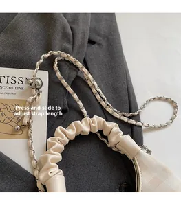 Detail of adjustable strap with silver ball slider on cream quilted chain bag