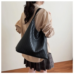 Close-up of black woven leather tote bag showing intricate craftsmanship and large capacity