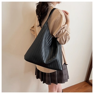 Detail of black woven leather tote bag showing large capacity and Intrecciato texture