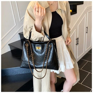 Détail du sac cabas classique en cuir matelassé noir avec d'élégantes bandoulières dorées