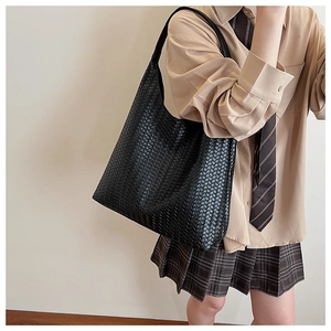 Detail of a large black woven leather hobo bag showing the intricate intrecciato pattern