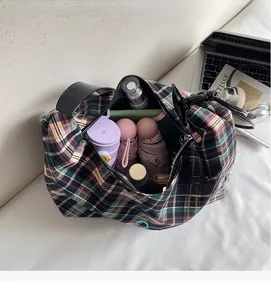 Vue de dessus montrant le grand intérieur du sac à carreaux avec des objets quotidiens