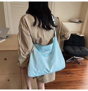 Detailed view of light blue tote bag with a white bow design in a modern setting