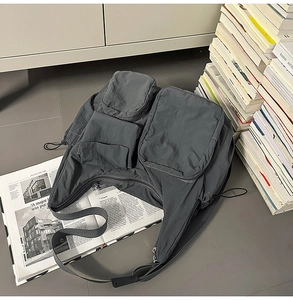 Detailed view of dark grey industrial messenger bag with multiple functional pockets