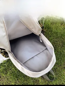 Vue interne du sac à dos blanc cassé montrant la grande capacité et la doublure grise