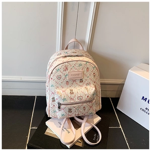 Detail view of the floral bear backpack with pink leather straps and a metal brand label