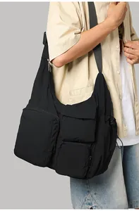 Detail of black multi-pocket crossbody messenger bag in waterproof nylon fabric