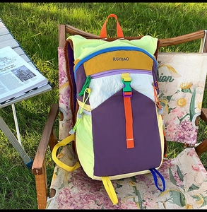 Outdoor camping scene showing a large capacity color-block backpack on a floral folding chair