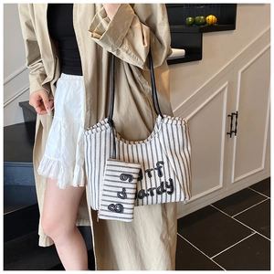 Detail of striped canvas tote bag set with surf hardy embroidery and shoulder strap