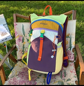 Detail of multi-color outdoor backpack with orange buckle on lightweight nylon fabric