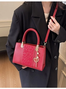 Elegant red wedding handbag with floral embossing and heart-shaped Double Happiness charm