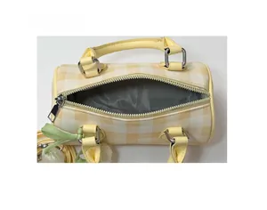 Top view of yellow plaid cylinder bag showing grey herringbone lining and spacious interior