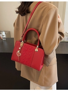 Elegant red wedding handbag with embossed pattern, woven handle and gold heart charm