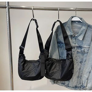 Detail of adjustable black nylon crossbody bags with multiple diagonal zipper pockets