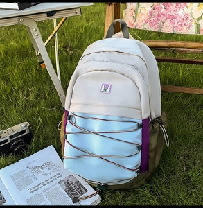 Détail d'un sac à dos en nylon multicolore avec cordons élastiques et broderie en plein air