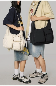 Detail view of multi-pocket vintage messenger bags in off-white and black nylon fabrics