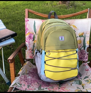 Détail d'un sac à dos en nylon multicolore avec cordon sur une chaise de camping