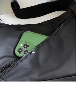 Detail of black crossbody bag with zip pocket showing storage capacity for a smartphone