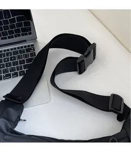 Close-up of adjustable nylon shoulder strap with durable plastic buckle on a black bag