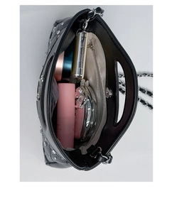 Internal view of black quilted bag with magnetic closure and silver hardware details
