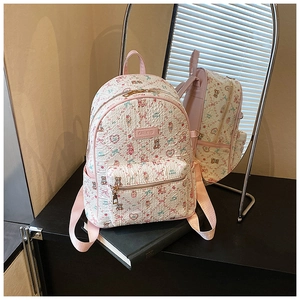 Detail of white backpack with pink cartoon prints, top handle and front zipper pocket