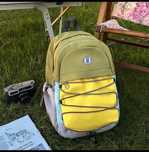 Détail du sac à dos patchwork coloré avec cordon élastique sur herbe avec camping