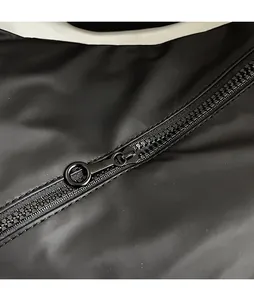 Detailed close-up of smooth black metal ring zipper pull on durable nylon dumpling bag