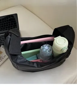 Top view of spacious black crossbody tote bag showing tablet, water bottle and umbrella inside