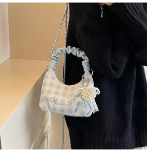 Detail of blue plaid dumpling bag with scrunchie handle and pearl pendant charm
