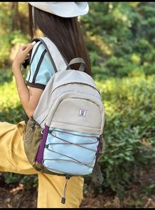 Détail du sac à dos en nylon multicolore avec cordes élastiques et écusson floral
