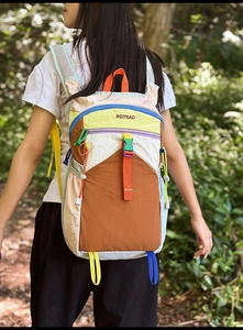 Detail of multi-color nylon outdoor backpack with side drawstring and brand logo