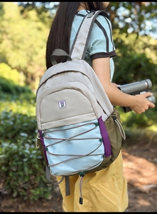 Détail d'un sac à dos de randonnée multicolore avec système de cordon élastique avant