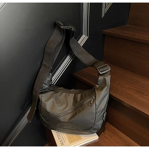 Detail of dark olive crescent bag with industrial buckle and smooth nylon texture